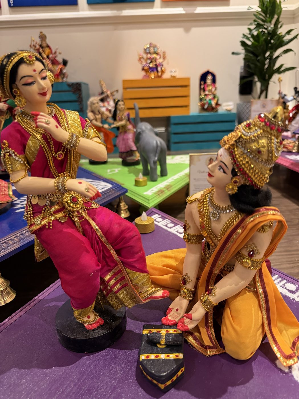 Golu dolls of Murugan kneeling and placing Devayani’s foot on the ammi, a grinding stone